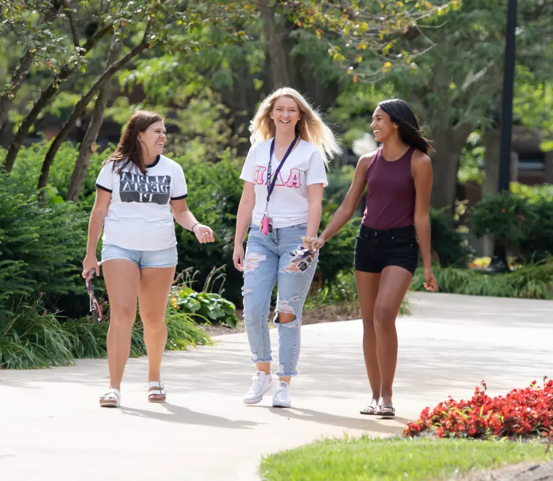 Three female students walking on campus during Festival on Founders